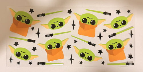 A sheet of Peel, Stick Star Wars decals featuring Baby Yoda (The Child) with green lightsabers and black star accents on a white backing.
