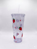 A clear plastic travel tumbler with a matching lid and straw, decorated with a pattern of red strawberries and pink flowers